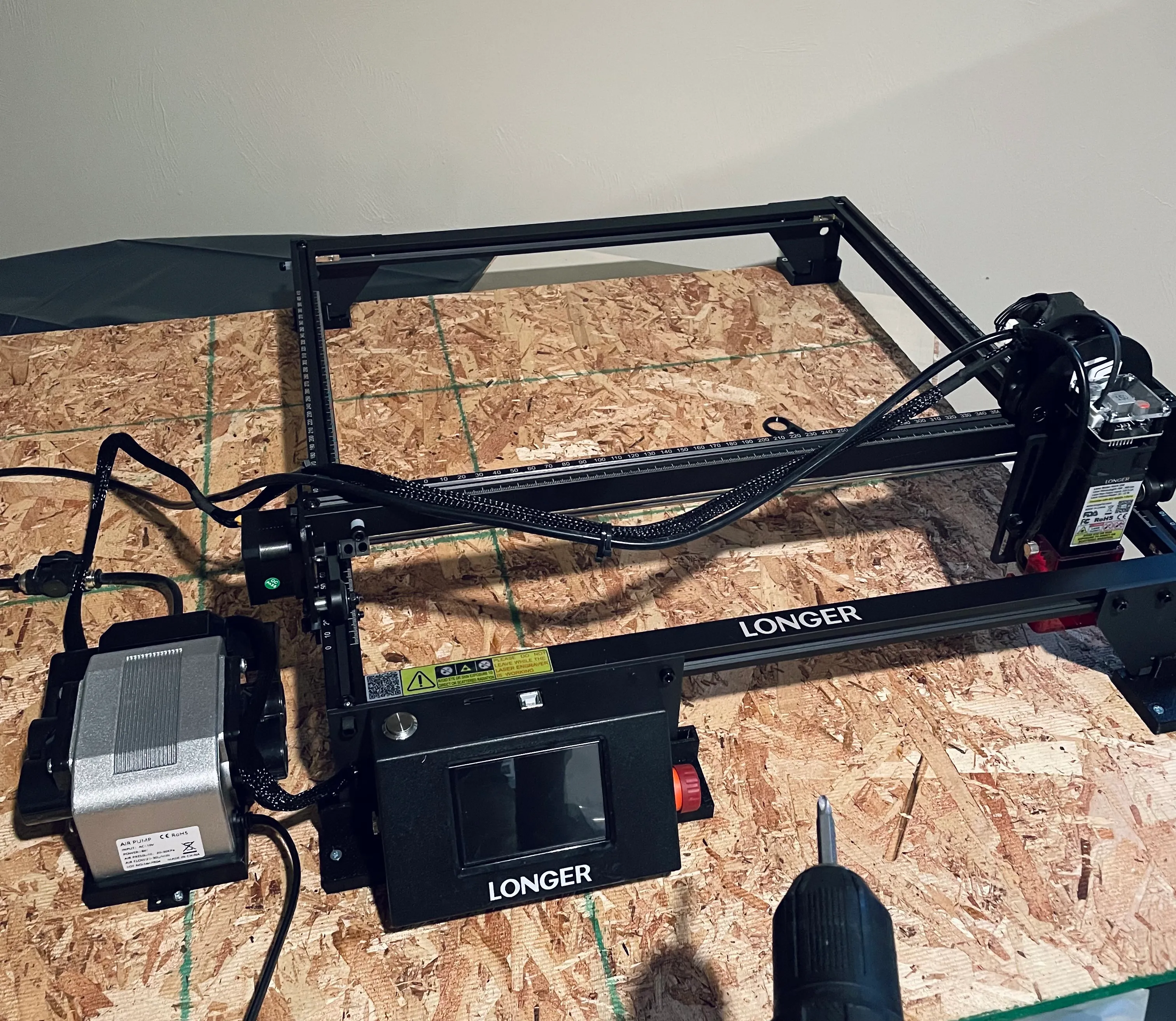 Laser engraver mounted on a wooden spillboard base